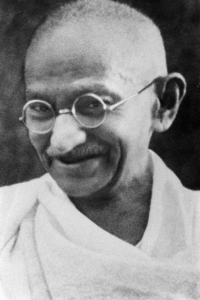 Mahatma Gandhi lächelnd: Ikonisches Foto des Gründers des gewaltlosen Widerstands mit seiner typischen runden Brille.
